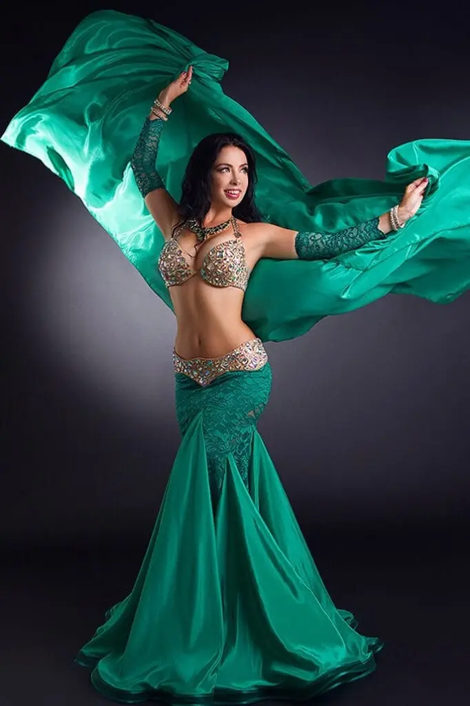Belly dancer for hire swirling a green silk veil in a beaded costume