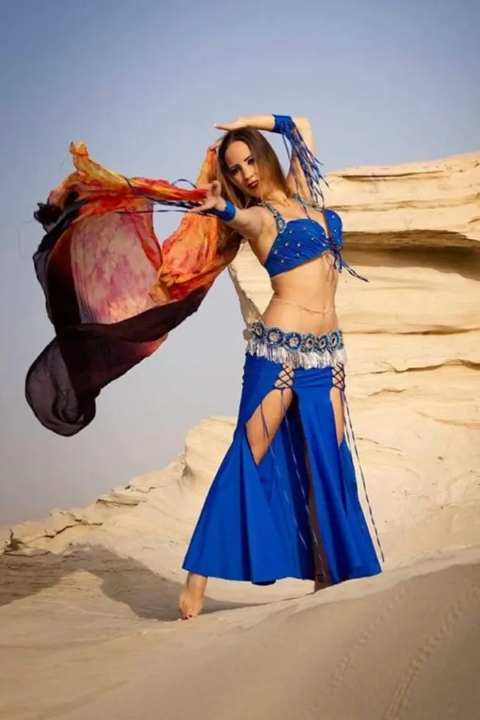 Belly dancer with a flowing veil and a royal blue costume